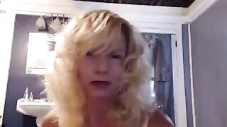 A mature woman caresses herself with a toy in the bathroom, showcasing her stunning big tits