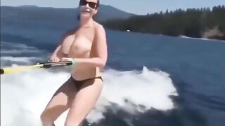 A topless girl has fun on the water skiing