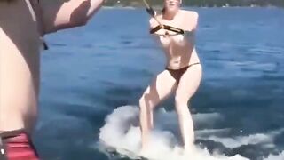 A topless girl has fun on the water skiing