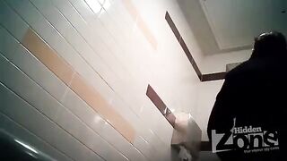 A camera has been placed in the woman's toilet, and she is peeing