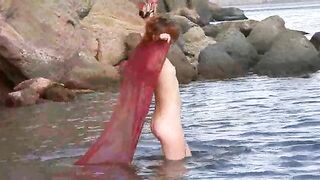 A sexy girl has small wet boobs while walking outside naked