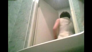 A girl is peeing in the toilet, not aware of the camera