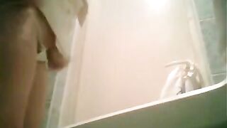 A girl is peeing in the toilet, not aware of the camera