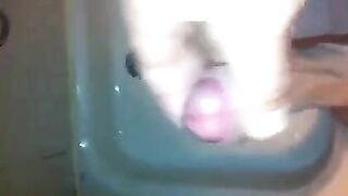 The kid caresses himself with his hand in the shower, trying not to cum