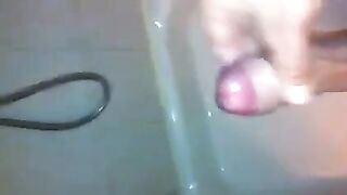 The kid caresses himself with his hand in the shower, trying not to cum