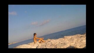 A hot girl is basking in the sun completely naked