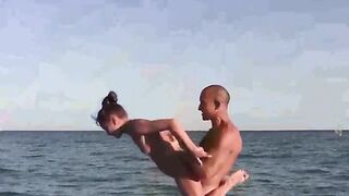 Nudist girl practices acrobatics on the bare beach