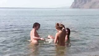 A group of naked people are having fun on the beach without any clothes
