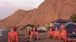 A group of nudists play volleyball without any clothes