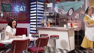 A very appetizing girl is working as a waitress on a table