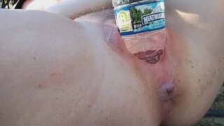 A woman reaches the peak of pleasure while masturbating outdoors
